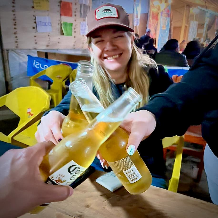 Three friends clicking together Corona beer in a "cheers"