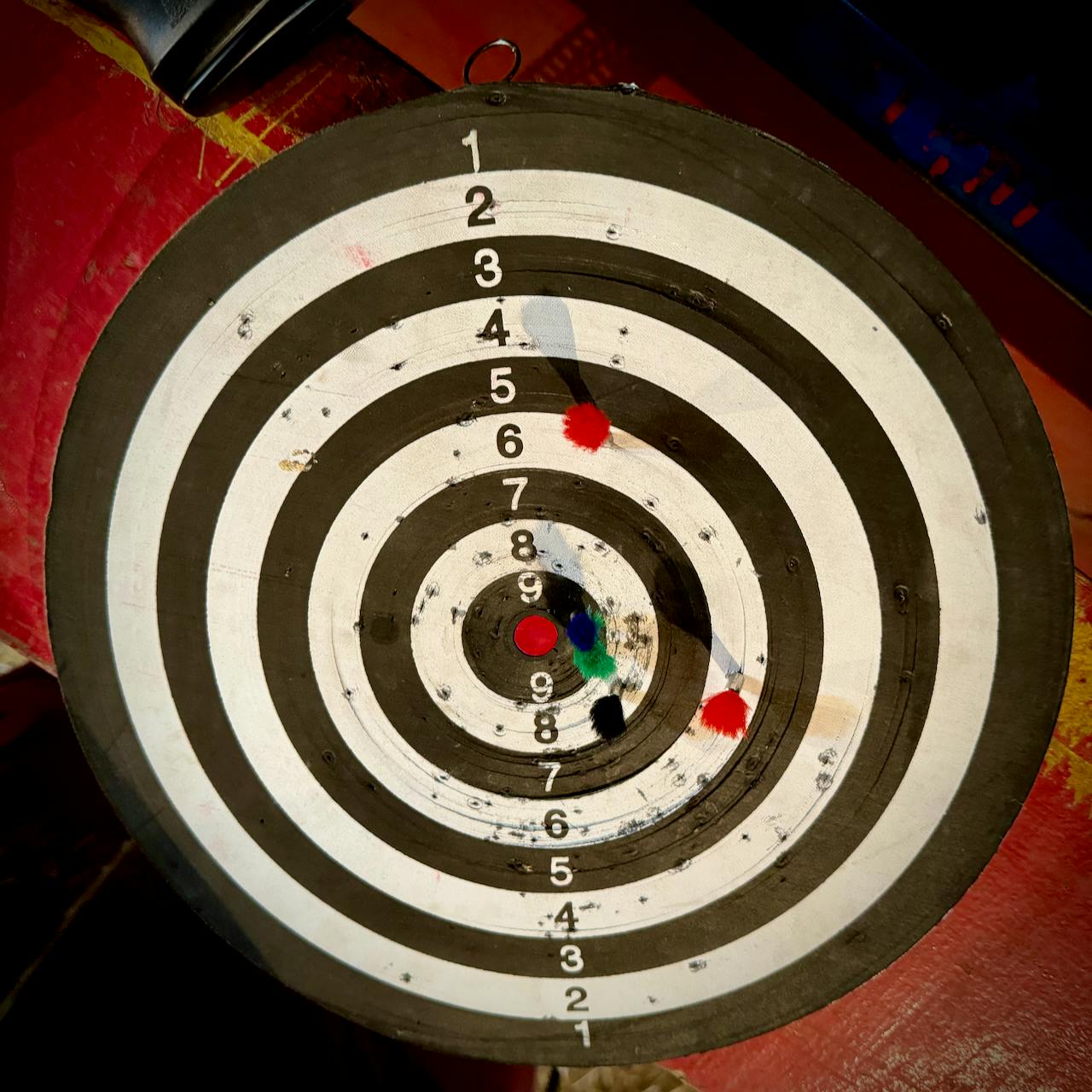 Dart gun and target board, showing 2 dart on 6 points, 1 dart on 8 points, and 2 on 9 points, for a total of 38 points